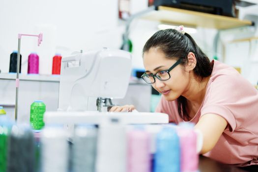 Embroidery, handicrafts, hobbies, SME business, family business, Portrait of Asian female designers are doing by designing patterns using automatic embroidery machines by customer order