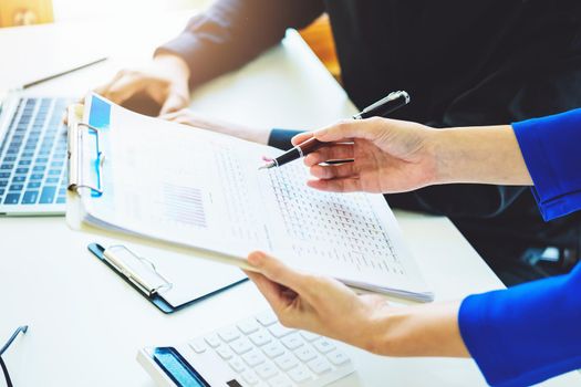 negotiation, analysis, discussion,asian female economist pointing out a document explaining the investment finance program to the company owner to plan marketing and hedging business risks