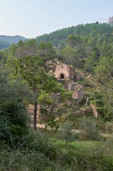 Jinquer, Castellon, Spain. Houses in ruins of an abandoned village in the middle of the vegetation. Mountain, group of houses. roads, Spanish Civil War