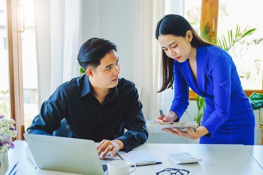 negotiation, analysis, discussion,asian female economist pointing out a document explaining the investment finance program to the company owner to plan marketing and hedging business risks