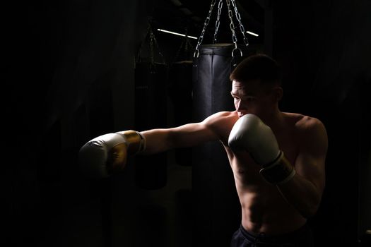 Athlete practices the The bag boxer blows glove black young professional boxing, In the afternoon strong gloves for punch and fist competitive, training sweat. Athletic model box, sexy