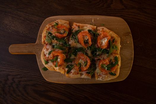 Pizza with salmon on roman dough with ruccola