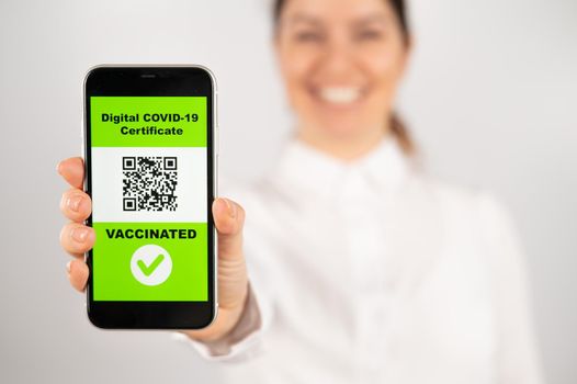 Woman showing smartphone with qr code about vaccination