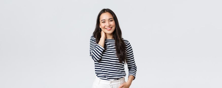 Lifestyle, people emotions and casual concept. Joyful beautiful asian woman in stylish casual clothes, touch neck blushing and smiling, having small talk at romantic date.