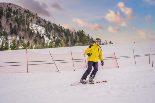 Ski instructor at training track showing students how to ski.