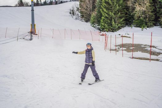 Woman learning to ski. Young woman skiing on a snowy road in the mountains.