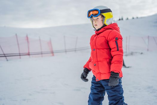 Child skiing in mountains. Active toddler kid with safety helmet, goggles and poles. Ski race for young children. Winter sport for family. Kids ski lesson in alpine school. Little skier racing in snow.