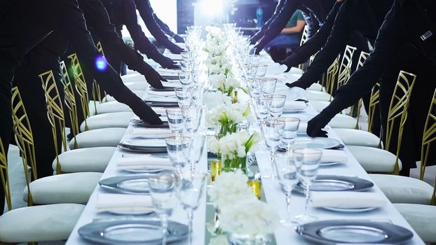 Large group of waiters serving a banquet