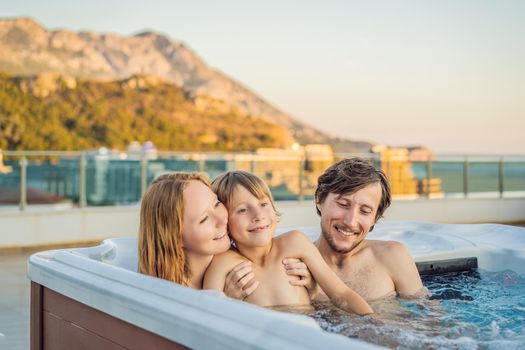 Portrait of young carefree happy smiling happy family relaxing at hot tub during enjoying happy traveling moment vacation. Life against the background of green big mountains.