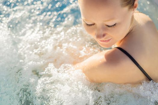 Portrait of young carefree happy smiling woman relaxing at hot tub during enjoying happy traveling moment vacation life against the background of green big mountains.