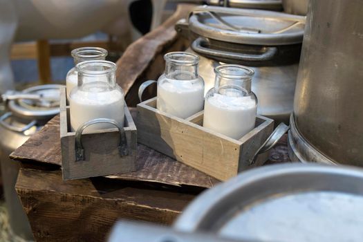 Milk - decoration on farm. Agriculture, farming. Farmer milk in bottles. Natural milk, organic milk. Vintage ornament with hay, straw and bottles with yogurt. Farmer product. Rustic decor. Products