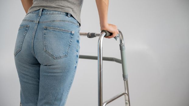 A woman is walking with a walker on a white background.