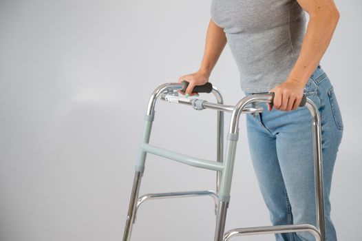 A woman is walking with a walker on a white background.