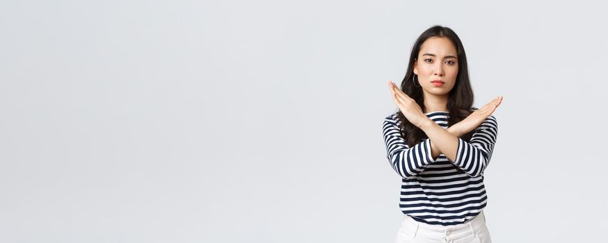 Lifestyle, beauty and fashion, people emotions concept. Serious-looking displeased asian woman tell to stop, showing cross sign in prohibition, disapprove action, give warning or restrain someone.