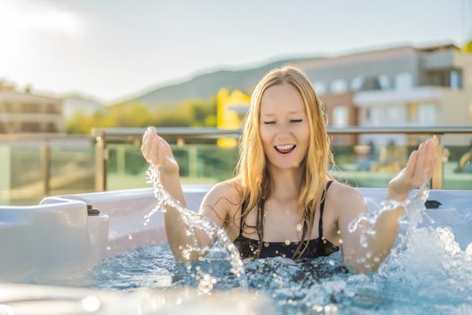 Portrait of young carefree happy smiling woman relaxing at hot tub during enjoying happy traveling moment vacation life against the background of green big mountains.