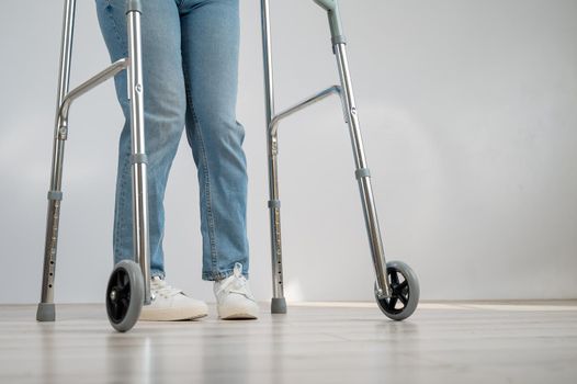 Close-up of female legs with walkers. The girl walks with the help of special equipment