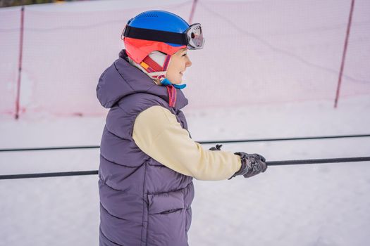 Woman skier climbs a mountain on a ski lift for beginners.