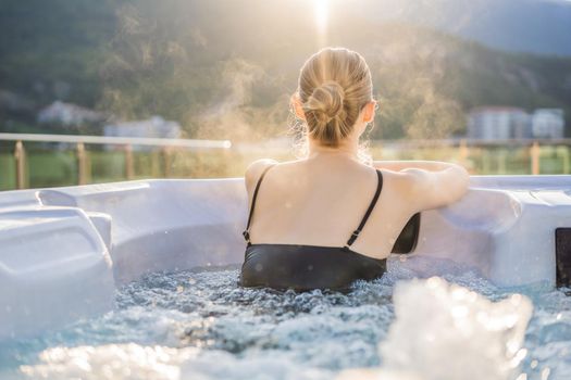 Portrait of young carefree happy smiling woman relaxing at hot tub during enjoying happy traveling moment vacation life against the background of green big mountains.