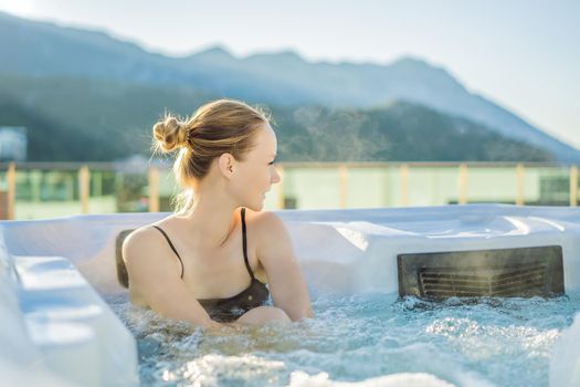 Portrait of young carefree happy smiling woman relaxing at hot tub during enjoying happy traveling moment vacation life against the background of green big mountains.