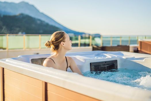 Portrait of young carefree happy smiling woman relaxing at hot tub during enjoying happy traveling moment vacation life against the background of green big mountains.