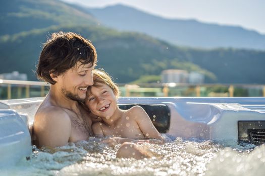 Portrait of young carefree happy smiling happy family relaxing at hot tub during enjoying happy traveling moment vacation. Life against the background of green big mountains.