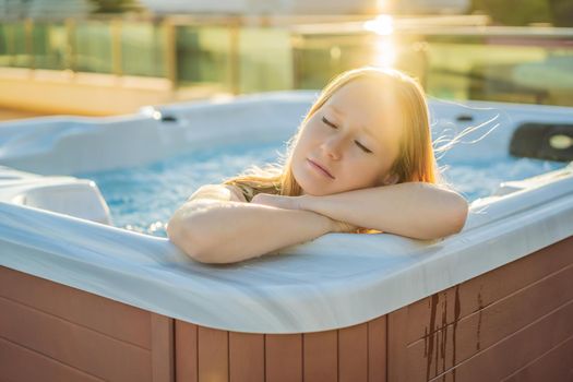 Portrait of young carefree happy smiling woman relaxing at hot tub during enjoying happy traveling moment vacation life against the background of green big mountains.