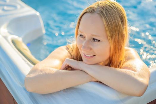 Portrait of young carefree happy smiling woman relaxing at hot tub during enjoying happy traveling moment vacation life against the background of green big mountains.