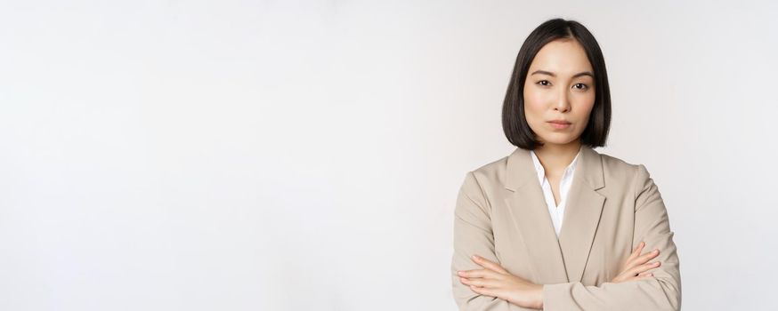 Confident female entrepreneur, asian business woman standing in power pose, professional business person, cross arms on chest, standing over white background.