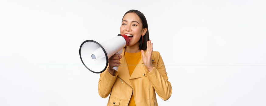 Attention announcement. Image of asian woman shouting in megaphone, recruiting, searching people, sharing information, standing over white background.