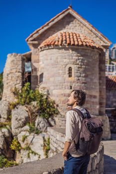 Young man tourist in the old town of Budva. Travel to Montenegro concept.