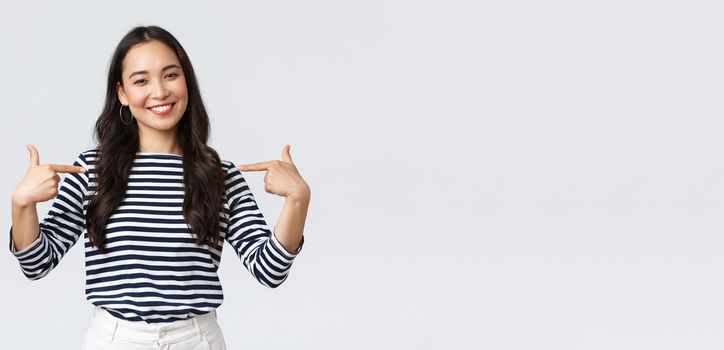 Lifestyle, beauty and fashion, people emotions concept. Smiling friendly-looking woman ready to help, pointing herself with pleasant look, bragging own accomplishments, whtie background.