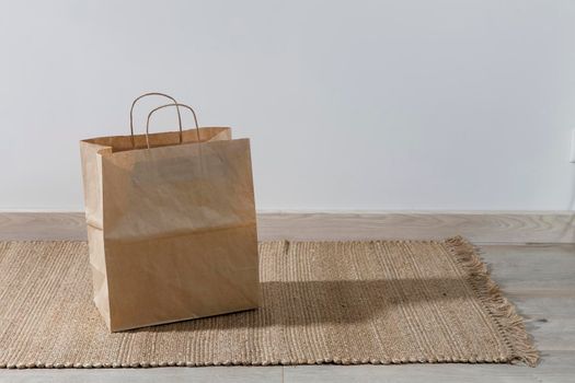 A paper bag is on a wicker rug. Copy space. Place for text