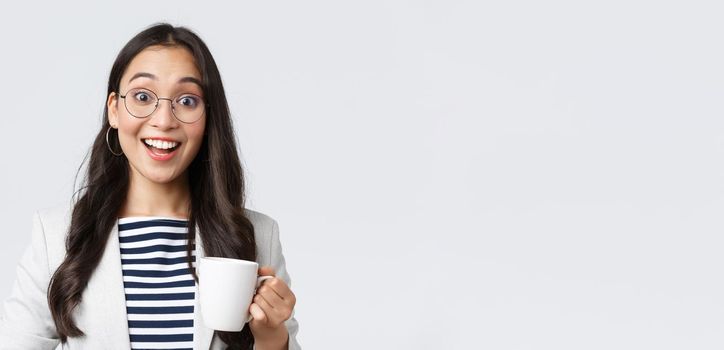Business, finance and employment, female successful entrepreneurs concept. Close-up of outgoing smiling asian office worker talking to coworker at office kitchen, drinking coffee.