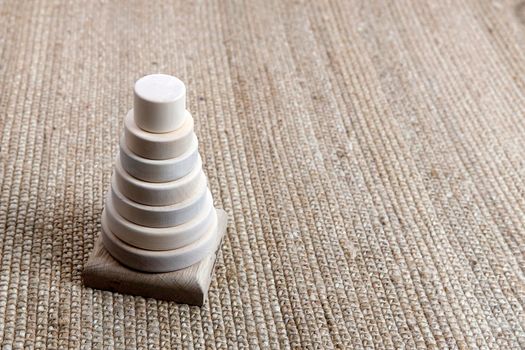 Wooden pyramid on a wicker mat, shadow from a palm tree. Empty space for text.