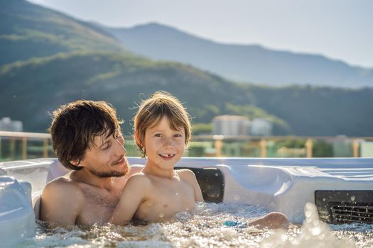 Portrait of young carefree happy smiling happy family relaxing at hot tub during enjoying happy traveling moment vacation. Life against the background of green big mountains.