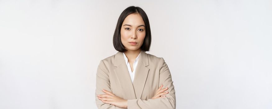 Confident female entrepreneur, asian business woman standing in power pose, professional business person, cross arms on chest, standing over white background.