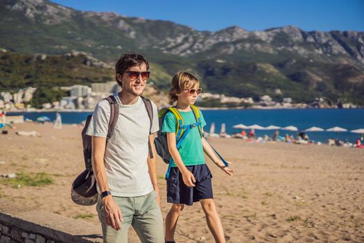 Dad and son tourists walks along the coast of Budva in Montenegro.