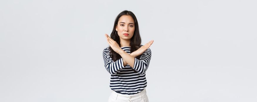 Lifestyle, beauty and fashion, people emotions concept. Serious-looking displeased asian woman tell to stop, showing cross sign in prohibition, disapprove action, give warning or restrain someone.