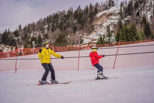 Instructor teaches boy skier to use on ski lift.