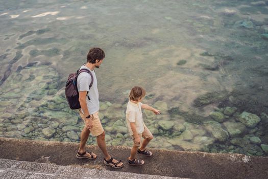 Dad and son tourists walks along the coast of Budva in Montenegro.