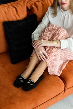 Photo of a womens legs in suede high-heeled shoes with a buckle. Selective focus