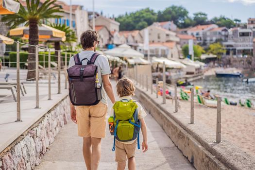 Dad and son tourists walks along the coast of Budva in Montenegro.