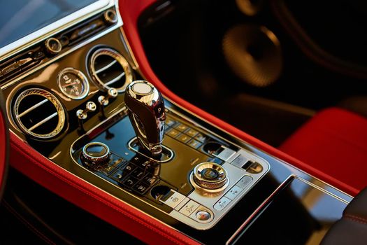 Automatic gear shift handle. Red luxury car Interior. Shallow doff