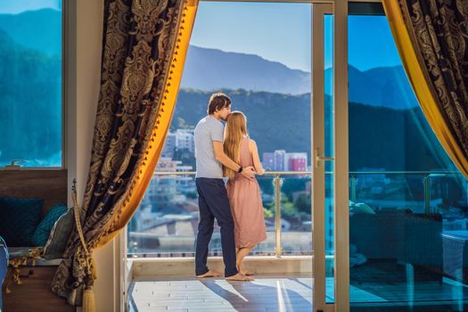 Couple on the balcony against the backdrop of mountains and city, Montenegro. life terrace pretty happiness summer home. Inspiration city romantic hotel.