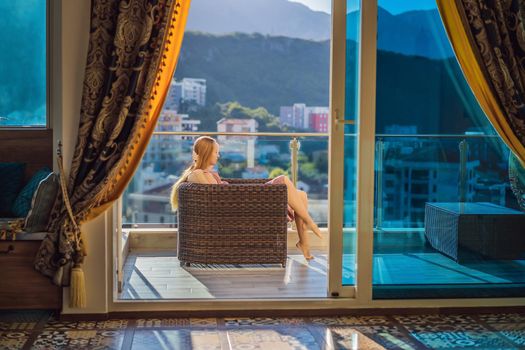 Woman on the balcony against the backdrop of mountains and city, Montenegro. life terrace pretty happiness summer home. Inspiration city romantic hotel.