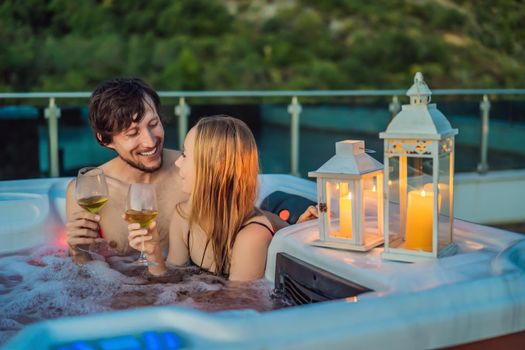 Portrait of young carefree happy smiling couple relaxing at hot tub during enjoying happy traveling moment vacation life against the background of green big mountains.