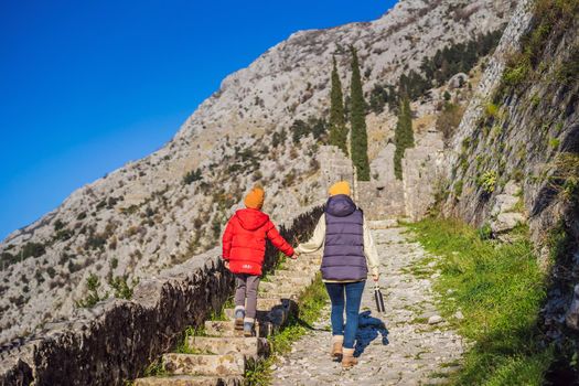 Mom and son travelers in Montenegro in Kotor Old Town Ladder of Kotor Fortress Hiking Trail. Aerial drone view.