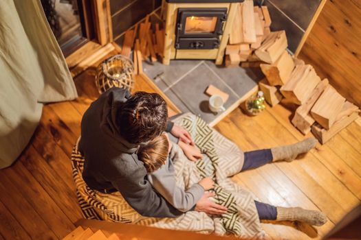 Dad and son spend time by the fireplace in Glamping. Rest in the mountains in Glamping. Cozy fireplace in a mountain house.