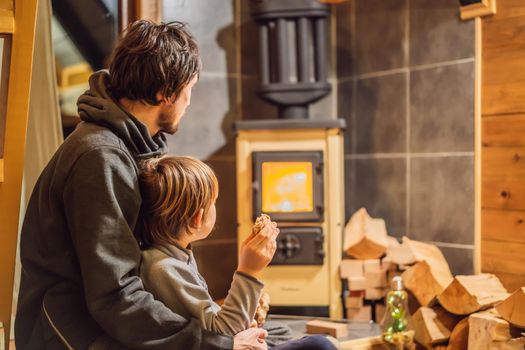 Dad and son spend time by the fireplace in Glamping. Rest in the mountains in Glamping. Cozy fireplace in a mountain house.