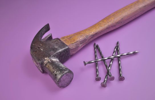 High Angle View of Hammer and Nails Isolated on a Lavender Purple Studio Background